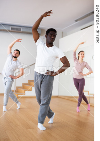 African-american man practicing classical dance moves with group 90296240
