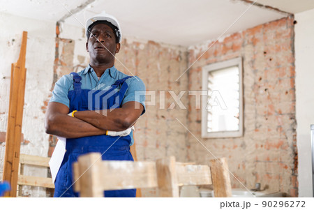 Portrait of man builder standing in construction site 90296272