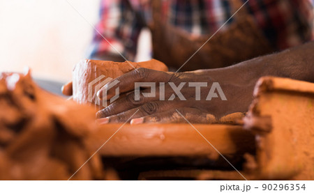 Hands working on pottery wheel Hands working on pottery wheel 90296354