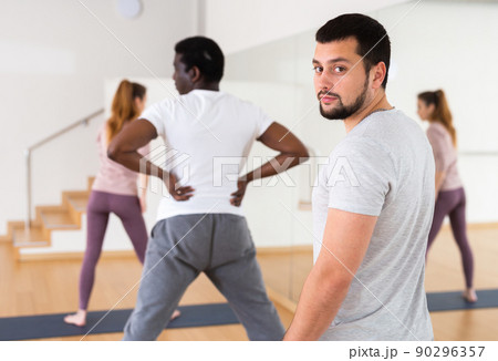 Man looking at camera during group fitness training in gym 90296357