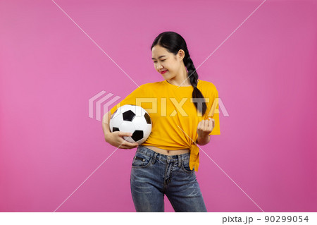 Asian Girl football fan over isolated pink background holding a soccer ball, sport concept Asian Girl football fan over isolated pink background holding a soccer ball, sport concept 90299054
