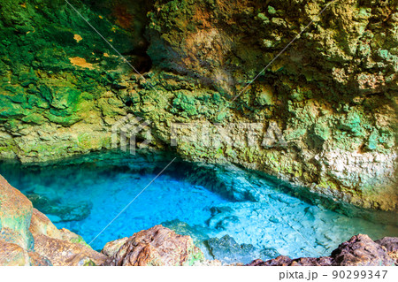 View of beautiful natural pool of crystal clear water formed in a rocky cave with stalagmites and stalagmites. Kuza cave in Zanzibar, Tanzania View of beautiful natural pool of crystal clear water formed in a rocky cave with stalagmites and stalagmites. Kuza cave in Zanzibar, Tanzania 90299347