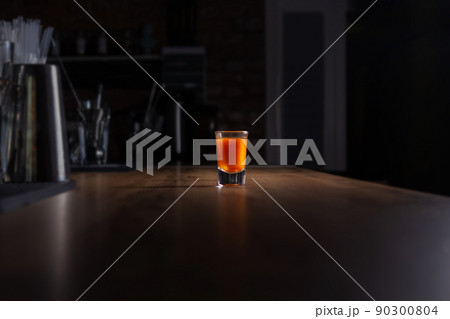 Drinking alone. Alcoholic shot at night bar.  90300804