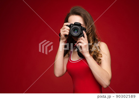 A beautiful bright woman with a camera in her 90302589