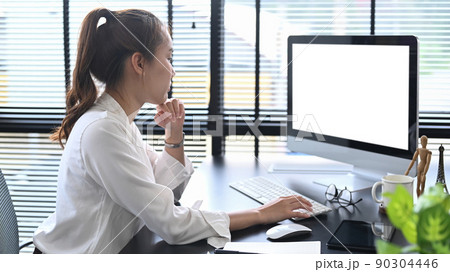 Side view thoughtful female manager looking at computer screen, working at modern workplace 90304446