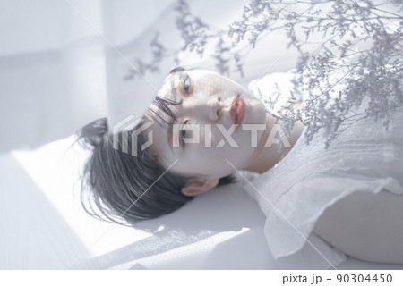 寝転ぶショートヘアの若い女性 寝転ぶショートヘアの若い女性 90304450
