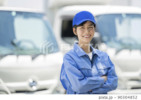 作業服を着てトラックの前に立つ若い女性 カメラ目線 ポートレート 作業服を着てトラックの前に立つ若い女性 カメラ目線 ポートレート 90304852