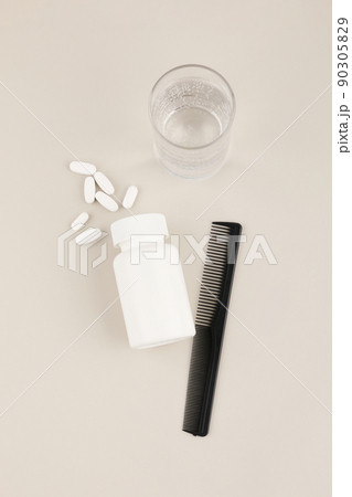 hair brush and pills, white background, medical creative concept photo 90305829