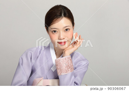 spring beauty concept, beautiful korean woman wearing hanbok getting her makeup 90306067