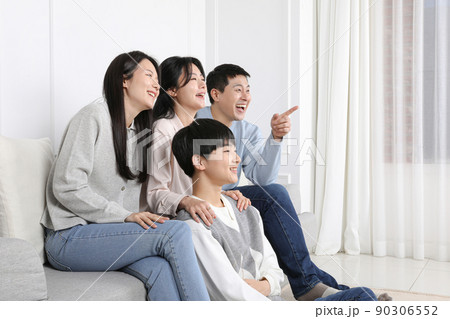Asian Korean family_Photo of a smiling family watching a funny TV scene Asian Korean family_Photo of a smiling family watching a funny TV scene 90306552