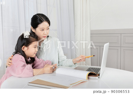 Asian Korean mother and daughter taking online classes on laptop Asian Korean mother and daughter taking online classes on laptop 90306553