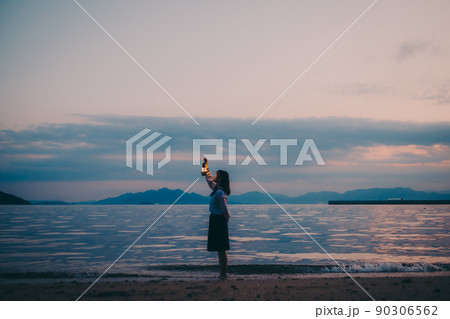制服姿の女子高生のシルエットと美しい夕焼け空 90306562
