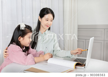 Asian Korean mother and daughter taking online classes on laptop Asian Korean mother and daughter taking online classes on laptop 90306563