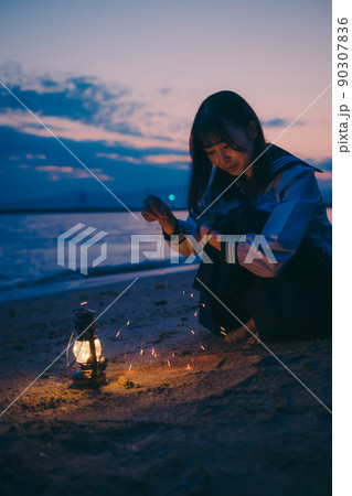 制服姿の女子高生と美しい夕焼け空 90307836