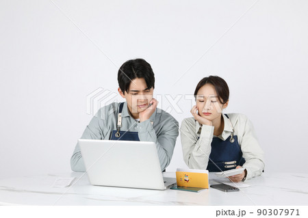 Asian Korean young man and woman startup concept_ are worried while looking at their bankbooks 90307971