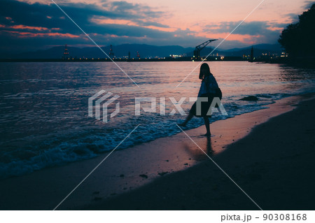 制服姿の女子高生のシルエットと美しい夕焼け空 90308168