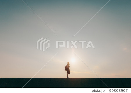 制服姿の女子高生と美しい夕焼け空 90308907