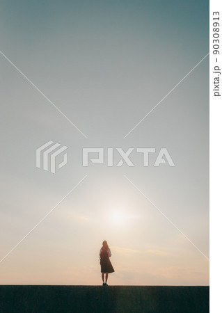 制服姿の女子高生と美しい夕焼け空 90308913