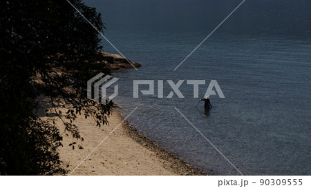 An old fisherman, looking for shrimp, near the typical Japanese beach 90309555