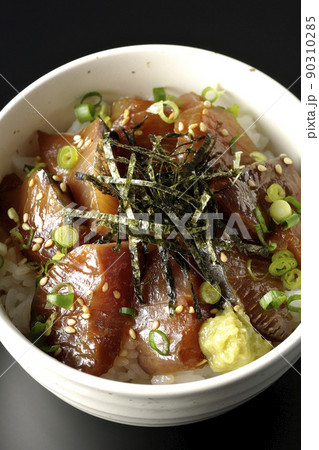 刻み海苔、万能葱、ワサビの乗ったワラサの漬け丼を黒背景で俯瞰撮影 90310285