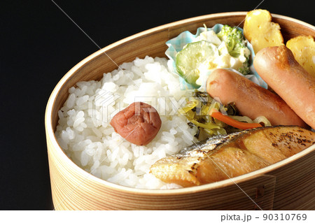 曲げわっぱに入っている鮭弁当を黒背景で撮影 90310769