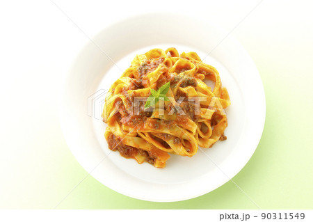 平打ちパスタのフィットチーネとトマトソースがよく絡んだミントの葉が添えられているボロネーゼを俯瞰撮影 90311549