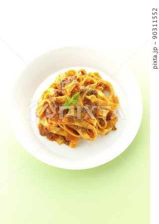 平打ちパスタのフィットチーネとトマトソースがよく絡んだミントの葉が添えられているボロネーゼを俯瞰撮影 90311552