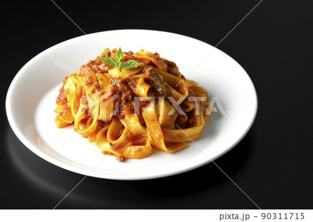 平打ちパスタのフィットチーネとトマトソースがよく絡んだボロネーゼを黒背景で撮影 平打ちパスタのフィットチーネとトマトソースがよく絡んだボロネーゼを黒背景で撮影 90311715