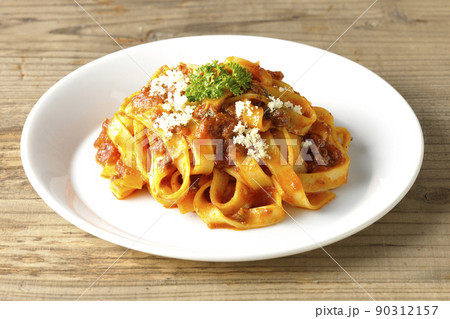 平打ちパスタのフィットチーネとトマトソースがよく絡んだボロネーゼにパルメザンチーズがけ 90312157