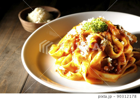 平打ちパスタのフィットチーネとトマトソースがよく絡んだボロネーゼにパルメザンチーズがけ 90312178