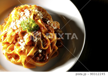 平打ちパスタのフィットチーネとトマトソースがよく絡んだボロネーゼにパルメザンチーズがけを俯瞰で撮影 平打ちパスタのフィットチーネとトマトソースがよく絡んだボロネーゼにパルメザンチーズがけを俯瞰で撮影 90312245