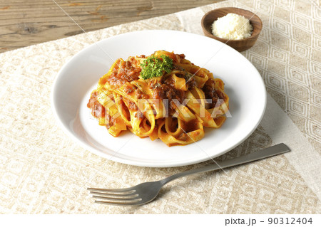 平打ちパスタのフィットチーネとトマトソースがよく絡んだボロネーゼにパルメザンチーズを添えて 90312404