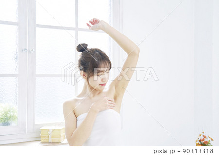 リビングで脇の下のケアをする女性 リビングで脇の下のケアをする女性 90313318