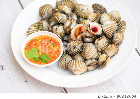 Cockles on white plate with seafood sauce on table background , Fresh raw shellfish blood cockle ocean gourmet seafood in the restaurant Cockles on white plate with seafood sauce on table background , Fresh raw shellfish blood cockle ocean gourmet seafood in the restaurant 90313604