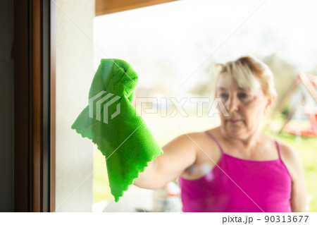 close up of woman's hand with special rag cleaning window 90313677