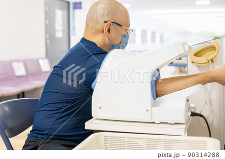 血圧計で血圧測定する男性 90314288