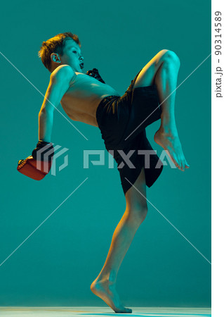 Young sportsmen, beginner fighter of mma sport in action isolated on cyan color background. Sport, education, action, motion concept. 90314589