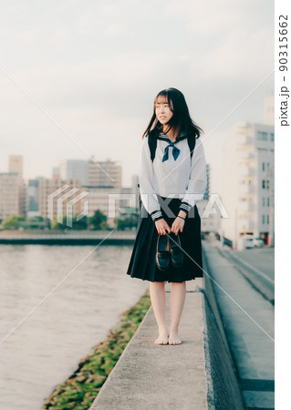 微笑む女子高生の後ろに流れる時間｜感情系素材 90315662