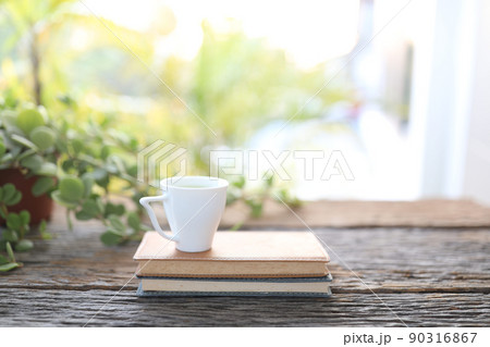 Small cup of coffee and notebooks and plant on wooden table Small cup of coffee and notebooks and plant on wooden table 90316867