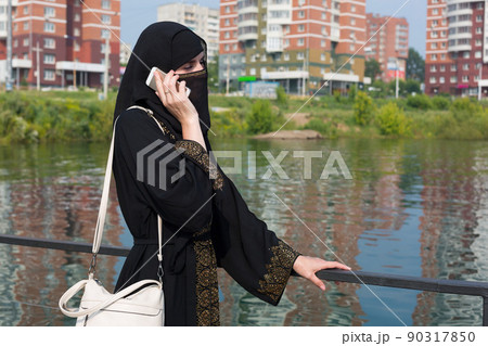 A Muslim immigrant woman calls her homeland from a European city 90317850