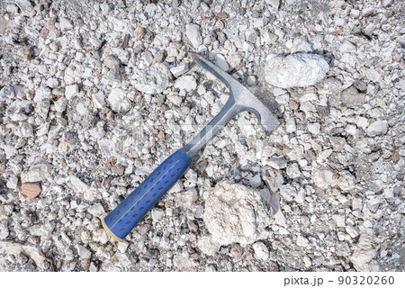 Geologist rock pick over magnesite rocks background Geologist rock pick over magnesite rocks background 90320260