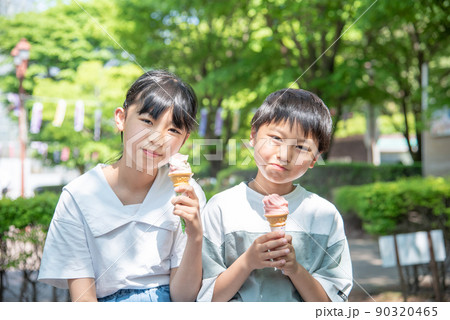 新緑の公園でソフトクリームを食べるアジア人の子供 90320465