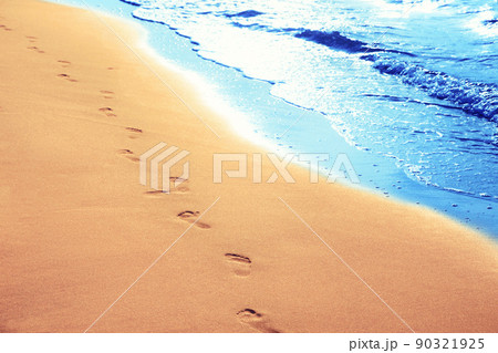 Walking on the beach, leaving footprints in the sand. Walking on the beach, leaving footprints in the sand. 90321925