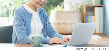 リビングでパソコンに向かうシニア女性 90321941