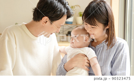 赤ちゃんを見つめる夫婦 赤ちゃんを見つめる夫婦 90323475