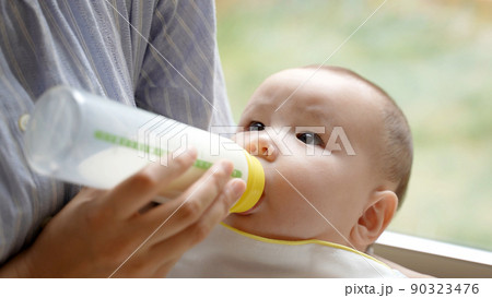 赤ちゃんにミルクをあげるお母さん 赤ちゃんにミルクをあげるお母さん 90323476