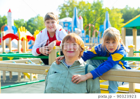 Grandmother walks with her grandchildren on playground 90323923