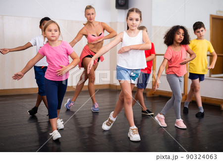 Tween girl training vigorous dance during group class 90324063