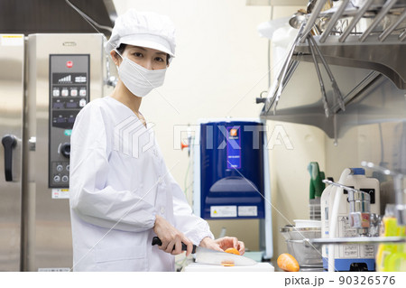 白衣を着て食事を作る女性 90326576