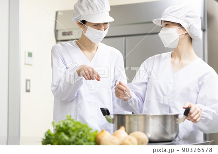 白衣を着て食事を作る女性 90326578